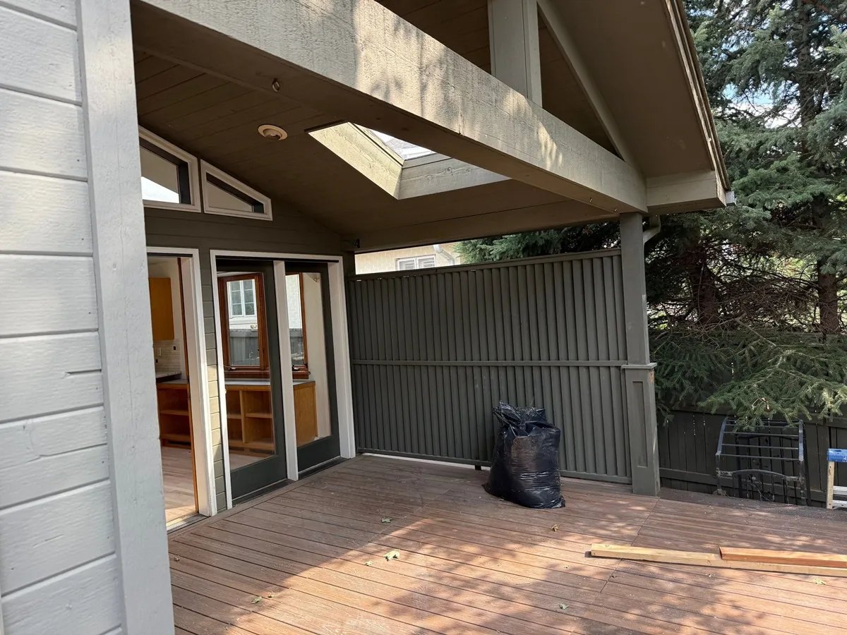 Covered wood deck with gray painted posts and a skylight, an Elements Painting deck project in Colorado