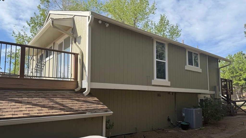 Two story home repainted dark blue gray with white trim in Boulder County, Colorado