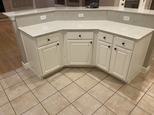 Angled kitchen island with white cabinet doors and stone counter, Elements Painting project on the Colorado Front Range