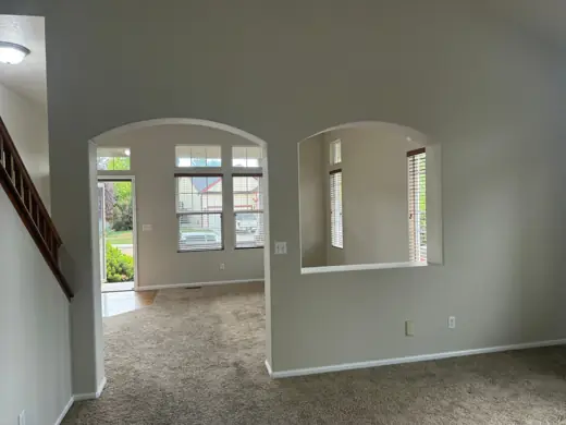 Arched windows in freshly painted beige living room with carpet, Elements Painting project on the Colorado Front Range
