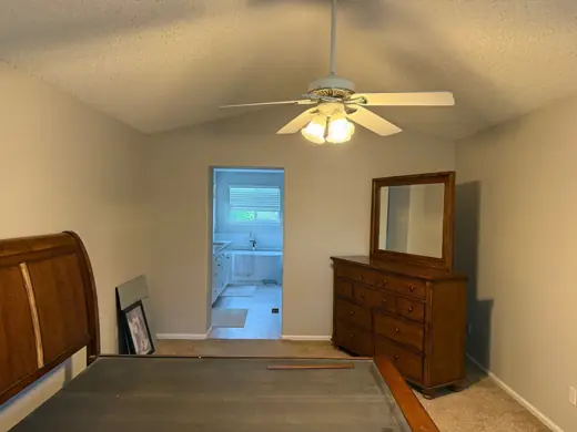 Bedroom with ceiling fan, wood dresser and beige walls, Elements Painting project on the Colorado Front Range