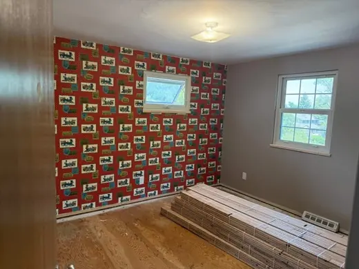 Before: bold patterned wallpaper bedroom, wood floor, Elements Painting project on the Colorado Front Range