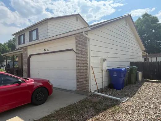 Cream home with white garage and brick accent, Elements Painting project on the Colorado Front Range