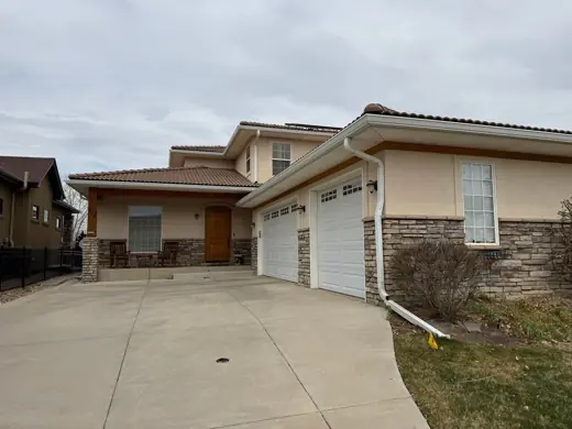 Cream stucco home driveway with two-story garage, Elements Painting project on the Colorado Front Range
