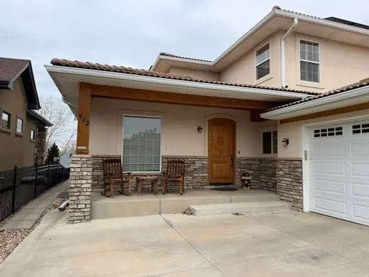 Cream stucco home entry with stone columns and garage, Elements Painting project on the Colorado Front Range