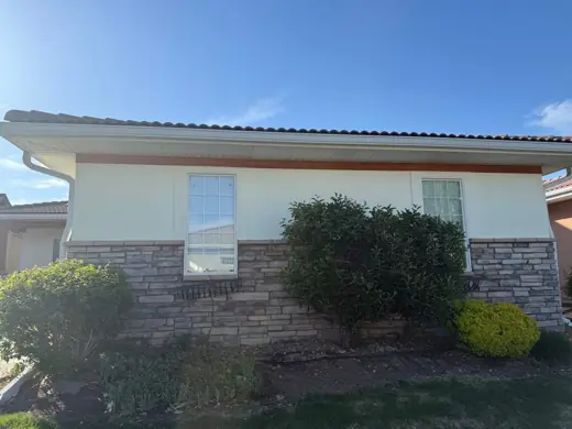 Cream stucco home with stone base and shrubs, Elements Painting project on the Colorado Front Range