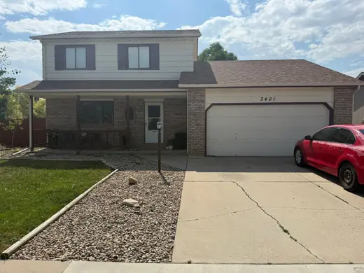 Cream two-story home with brick and white garage, Elements Painting project on the Colorado Front Range