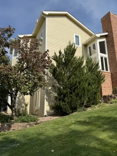 Cream two-story home with dark trim and lawn, Elements Painting project on the Colorado Front Range