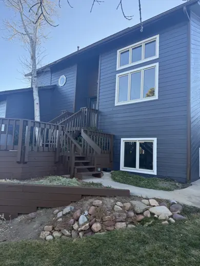 Dark blue home with tan trim and brown deck stairs, Elements Painting project on the Colorado Front Range