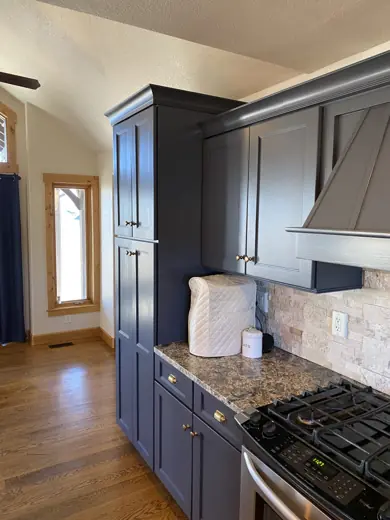 Dark gray cabinets beside range and granite counter, Elements Painting project on the Colorado Front Range