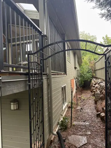 Dark gray-green siding with cream trim, iron gate, Elements Painting project on the Colorado Front Range