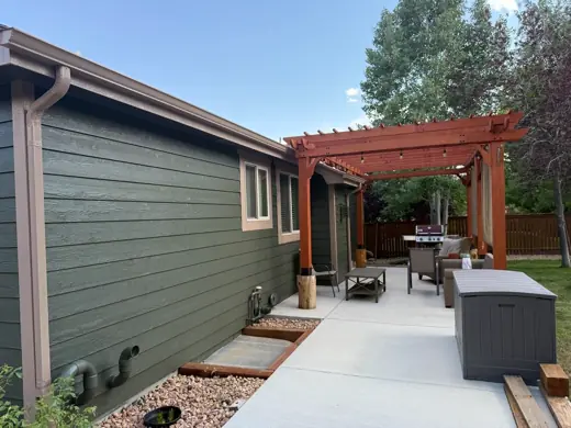Dark green home with tan trim, wood pergola, patio, Elements Painting project on the Colorado Front Range