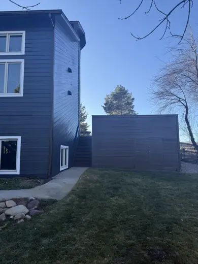 Dark navy home exterior corner with wood fence, Elements Painting project on the Colorado Front Range
