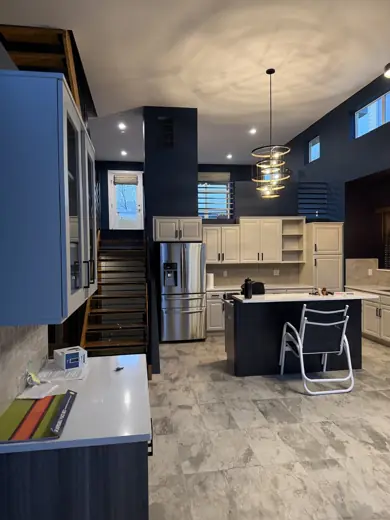 Dark navy kitchen wall, pendant lights, gray plank floor, Elements Painting project on the Colorado Front Range