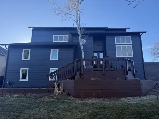 Dark navy two-story home with red-brown deck and railings, Elements Painting project on the Colorado Front Range