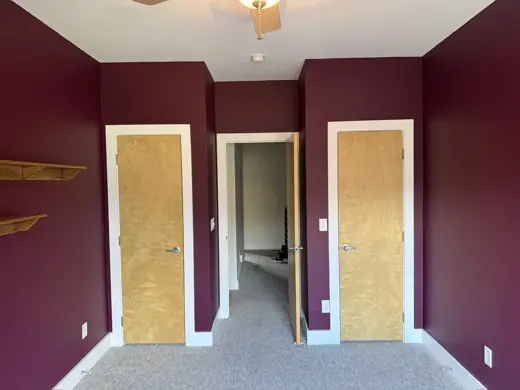 Deep burgundy bedroom walls with unfinished closet doors, Elements Painting project on the Colorado Front Range