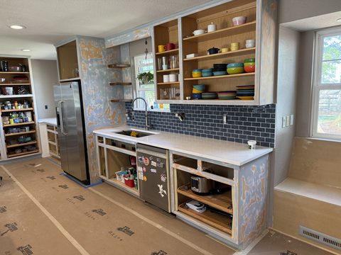 In progress: Full kitchen with stripped cabinets, doors off, floor protection, Elements Painting project on the Colorado Front Range