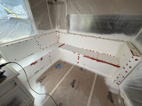 In progress: Primed white bench with filler spots, plastic-masked windows, Elements Painting project on the Colorado Front Range