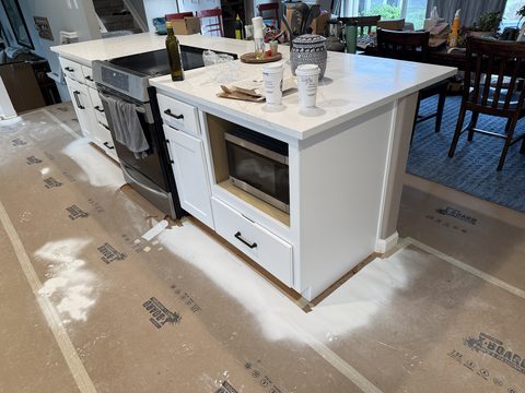 Cabinet painting, white kitchen island, floor still covered, Elements Painting project on the Colorado Front Range