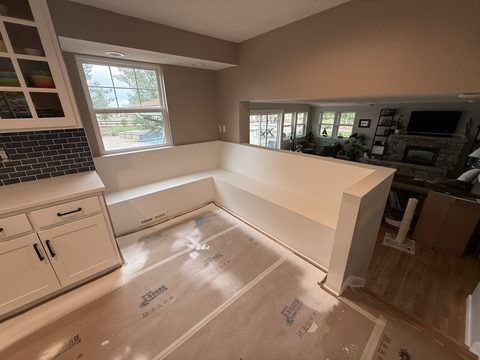 Built-in painting, white corner bench, taupe walls, white cabinets at left, Elements Painting project on the Colorado Front Range