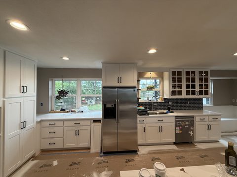 Cabinet painting, wide shot white kitchen, stainless fridge, Elements Painting project on the Colorado Front Range
