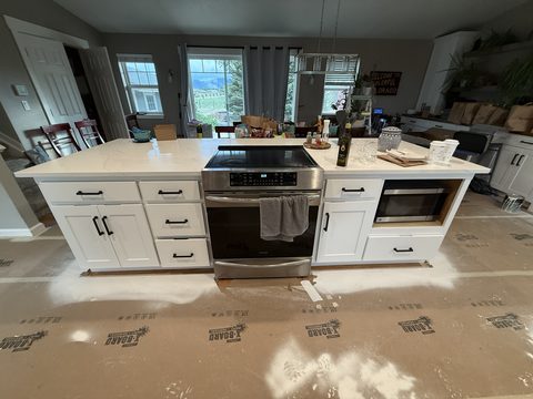 Cabinet painting, white island with range, dining area behind, Elements Painting project on the Colorado Front Range