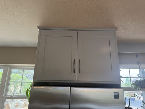 Cabinet painting, light grey upper cabinet over stainless fridge, textured ceiling, kitchen, Elements Painting project on the Colorado Front Range