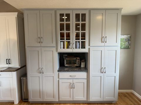 Cabinet painting, light grey floor-to-ceiling pantry cabinets with glass doors, greige walls, kitchen, Elements Painting project on the Colorado Front Range