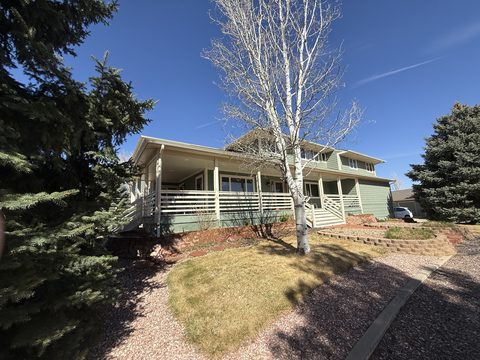 Exterior painting, two-story sage green home with white wraparound porch railing, birch tree, Elements Painting project on the Colorado Front Range