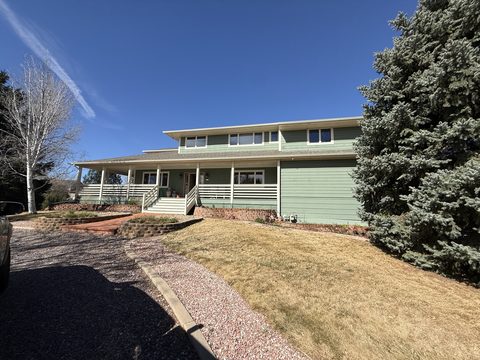 Exterior painting, two-story sage green home, white porch railing and trim, blue sky, front, Elements Painting project on the Colorado Front Range