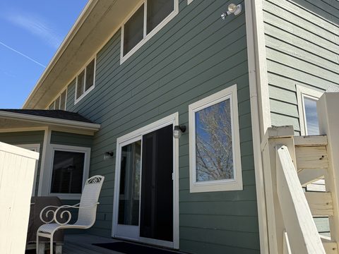 Exterior painting, sage green lap siding, white trim, sliding glass door, deck chair, Elements Painting project on the Colorado Front Range