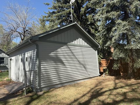 Exterior painting, light gray detached garage, board-and-batten gable, white trim, Elements Painting project on the Colorado Front Range