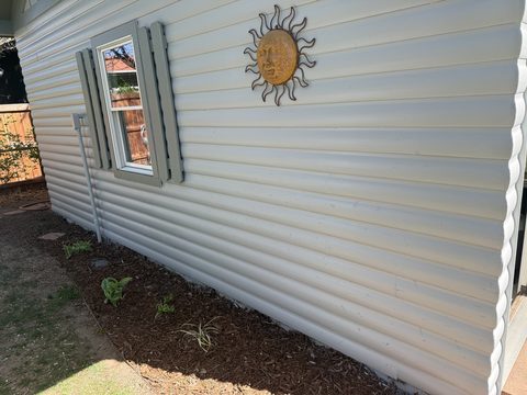 Exterior painting, close-up gray siding with gray shutters and sun ornament, Elements Painting project on the Colorado Front Range