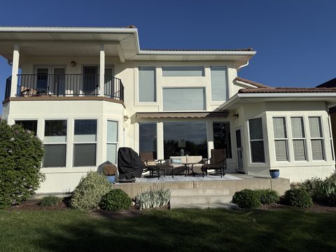 Exterior painting, cream stucco rear elevation, balcony, awning, patio furniture, evening light, Elements Painting project on the Colorado Front Range