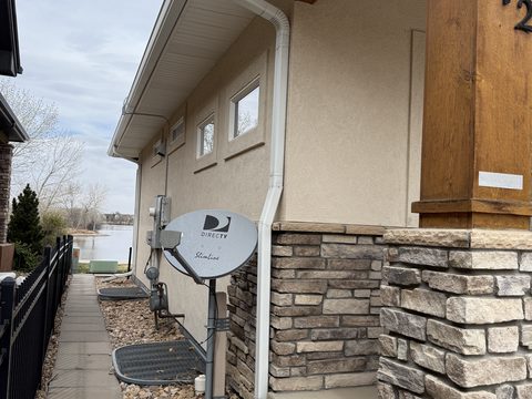 Exterior painting, beige stucco side wall, stone base, Elements Painting project on the Colorado Front Range