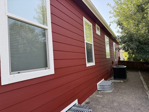 Exterior painting, barn-red lap siding side wall, crisp white window trim, Elements Painting project on the Colorado Front Range
