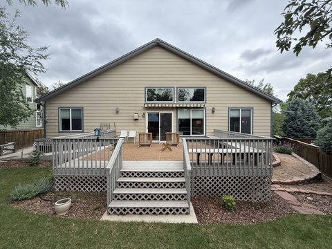Before painting: Rear of tan siding home with grey deck, Elements Painting project on the Colorado Front Range