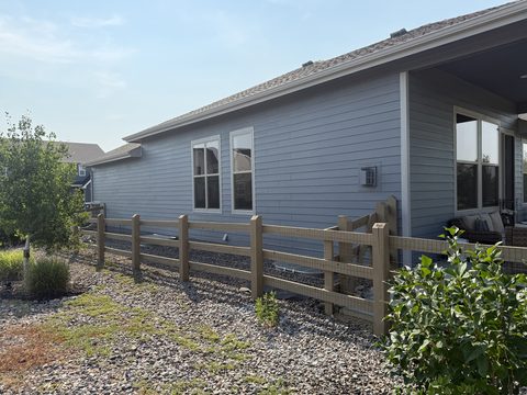 Exterior painting, blue-gray siding side elevation with windows, split-rail fence, Elements Painting project on the Colorado Front Range