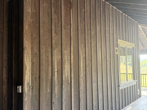 Exterior painting, dark brown stained board-and-batten siding under covered porch, Elements Painting project on the Colorado Front Range