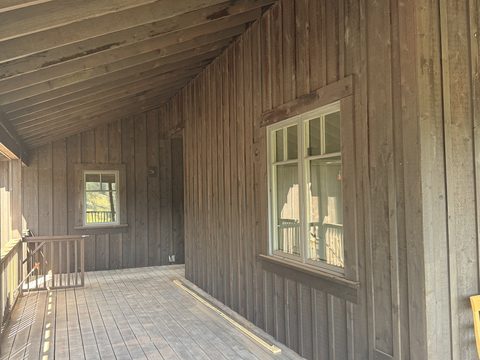 Exterior painting, covered porch, dark brown stained board-and-batten siding, grey window trim, mountain home, Elements Painting project on the Colorado Front Range