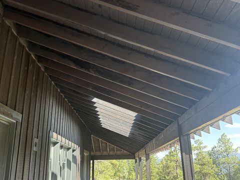 Exterior painting, porch ceiling with dark stained rafters and beams over board-and-batten wall, Elements Painting project on the Colorado Front Range