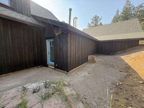 In progress: Dark brown siding with white door, shingled roofs, dirt grading, Elements Painting project on the Colorado Front Range