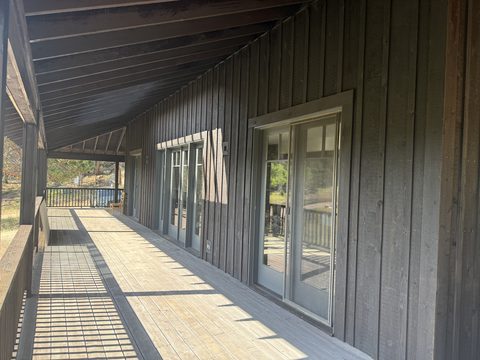 Exterior painting, long covered porch, dark brown siding, grey-trimmed french doors, warm light, Elements Painting project on the Colorado Front Range
