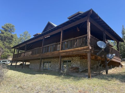 Exterior painting, dark brown stained log lodge, wraparound deck, stone base, Elements Painting project on the Colorado Front Range