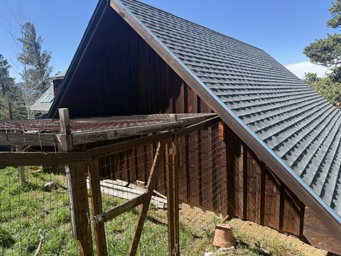 Exterior painting, dark brown stained A-frame side wall, wire fence enclosure, Elements Painting project on the Colorado Front Range