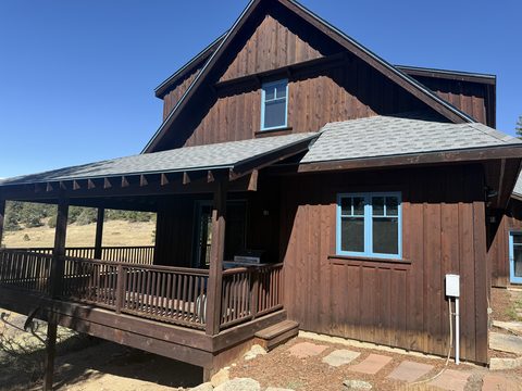 Exterior painting, dark brown stained mountain home, covered porch, blue window trim, sunny, Elements Painting project on the Colorado Front Range