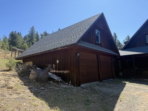 Exterior painting, dark brown stained garage side, barrel and debris, Elements Painting project on the Colorado Front Range