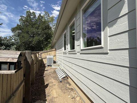 Exterior painting, light grey lap siding, white trim, side yard with AC unit and ladder, Elements Painting project on the Colorado Front Range