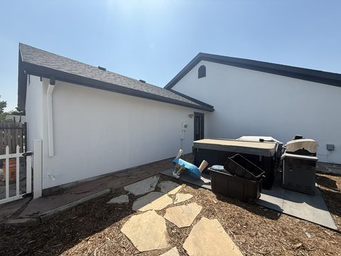 Exterior painting, white stucco, black trim, rear yard with hot tub and grill, Elements Painting project on the Colorado Front Range