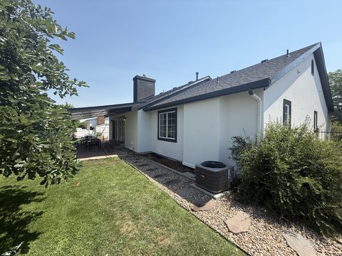 Exterior painting, white stucco rear and side, black fascia, lawn and AC unit, Elements Painting project on the Colorado Front Range